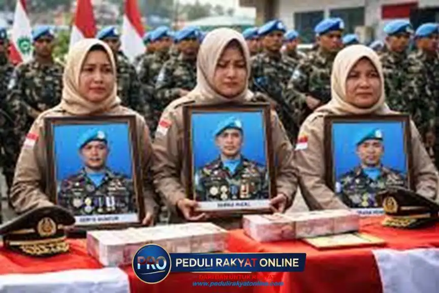 Para istri dari tiga prajurit TNI yang gugur tersebut memegang foto suaminya yang gugur di Lebanon